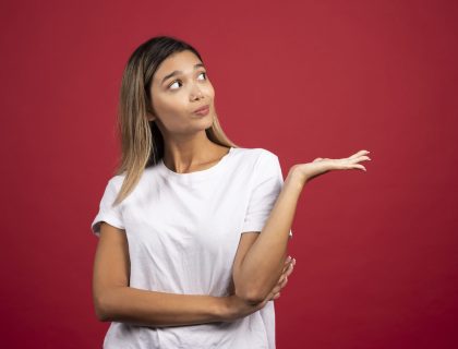 Young pretty woman posing on red background. High quality photo